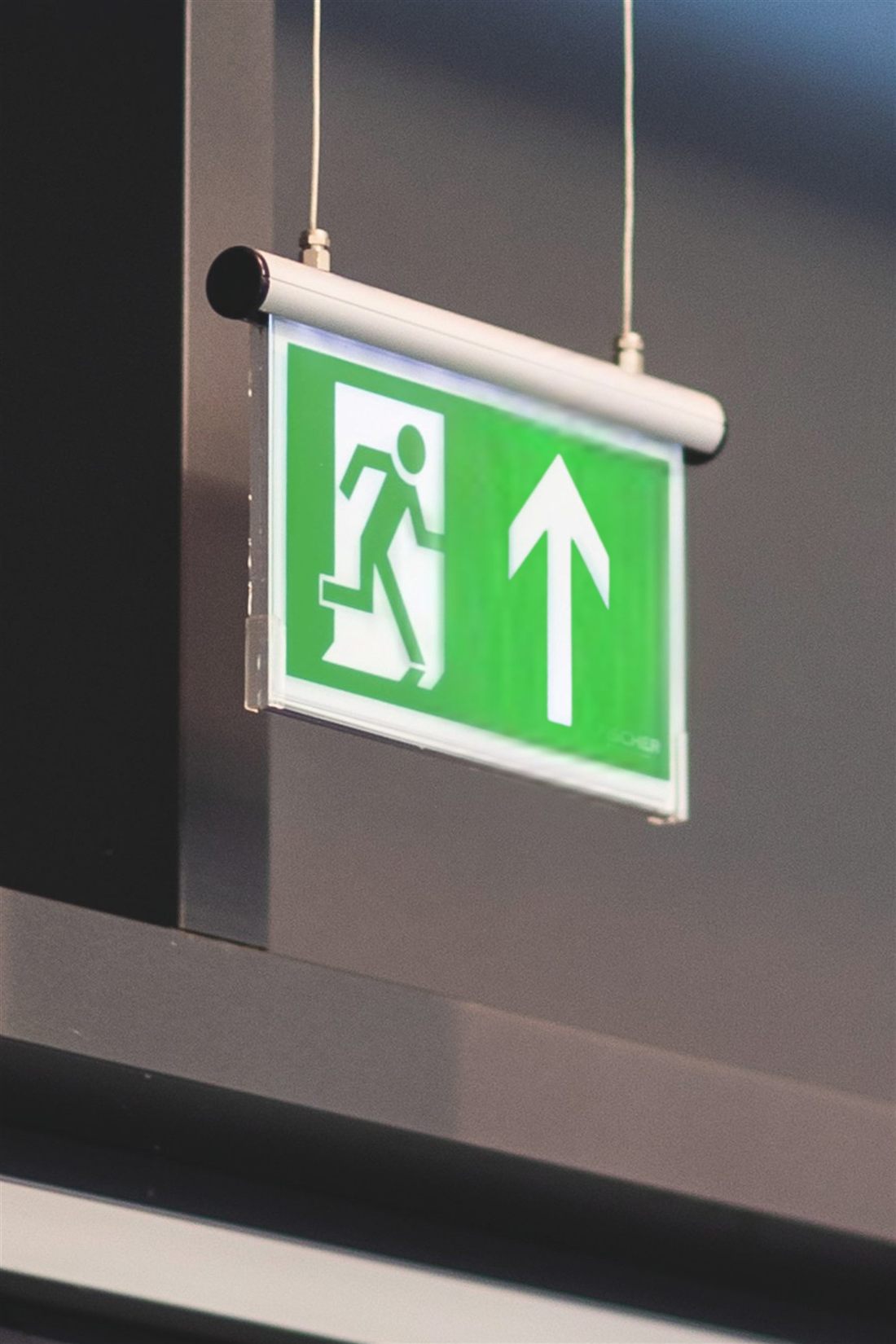Beleuchtetes Rettungszeichen über einem Fluchtweg