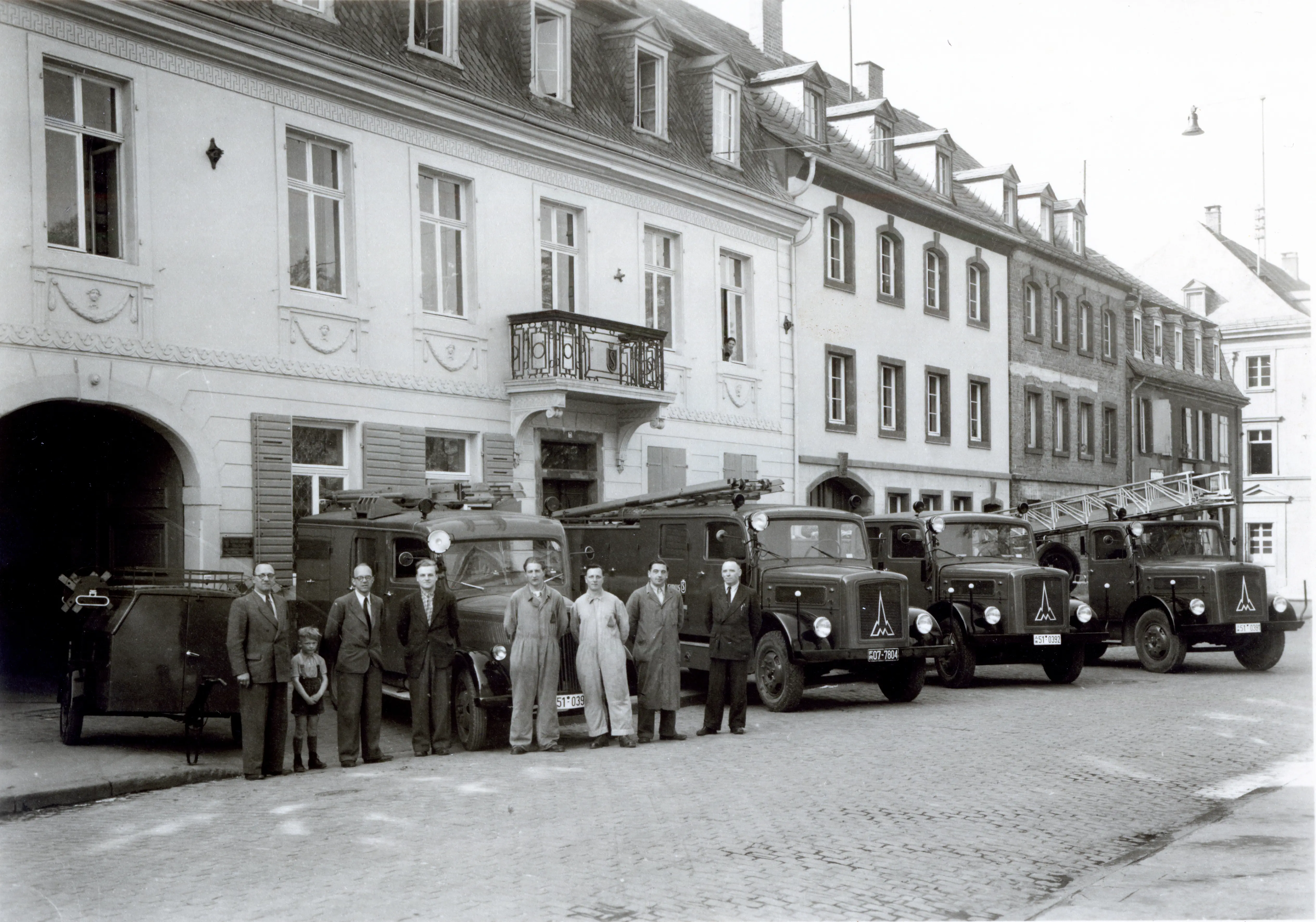 Historische Aufnahme ausgelieferter Löschfahrzeuge mit der Belegschaft